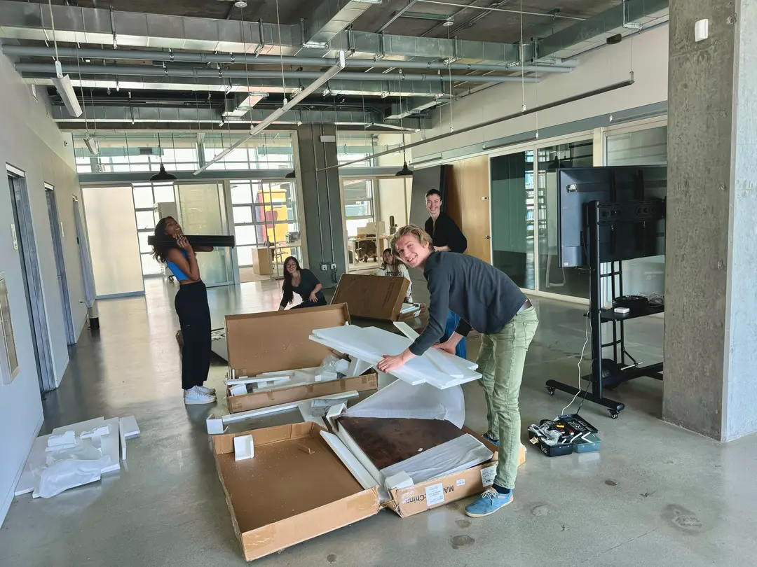 PlasticList team, full of pep, assembling our desks in late May